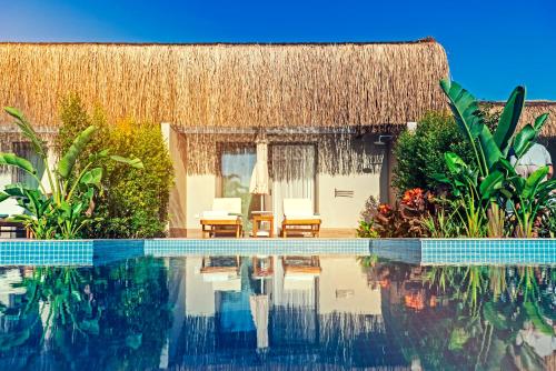 a resort with a swimming pool and a thatch roof at Royal Wings Hotel in Lara
