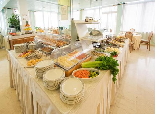 a buffet line with plates and food on it at Hotel Bristol in Sottomarina