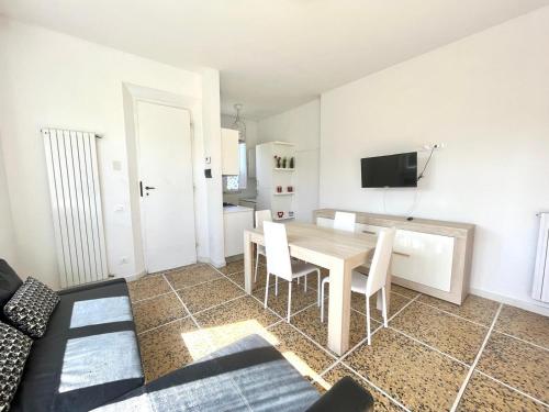 a living room with a table and chairs and a television at Pineta Apartament in Tirrenia