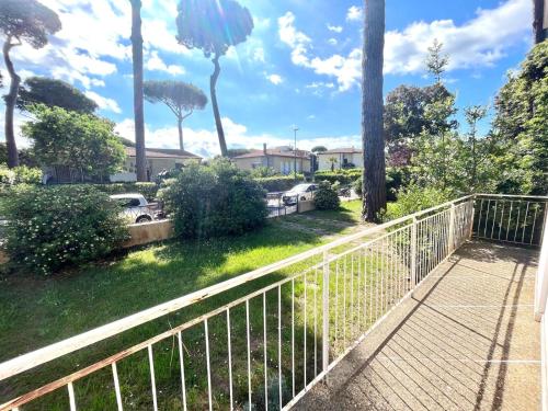 a balcony with a fence and cars on a street at Pineta Apartament in Tirrenia