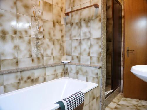 a bathroom with a tub and a sink at Villetta Giulietta-casa con giardino e parcheggio in Grado