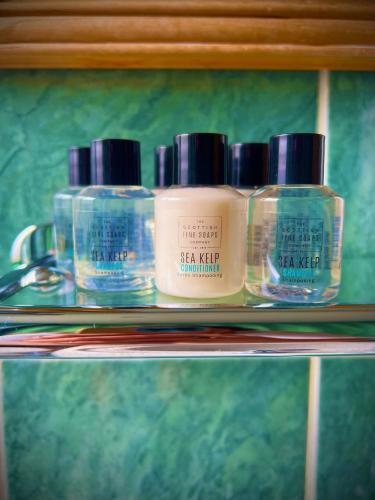 three bottles of soap on a shelf at Loch Ness Lodge Hotel in Drumnadrochit