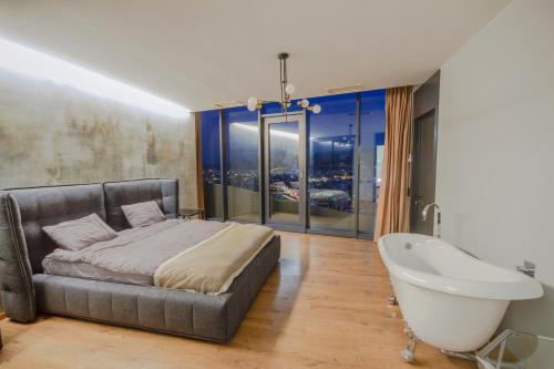 a bedroom with a large bed and a bath tub at Tbilisi view in Tbilisi City