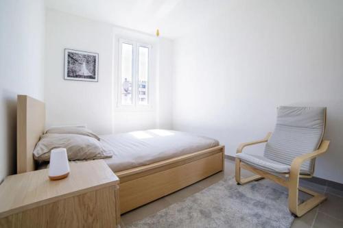 une chambre avec un lit, une chaise et une fenêtre dans l'établissement Appartement familial, lumineux, calme avec parking, à Cannes