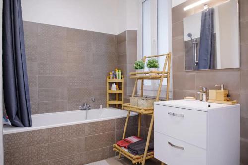 une salle de bain avec une baignoire et un lavabo dans l'établissement Appartement familial, lumineux, calme avec parking, à Cannes