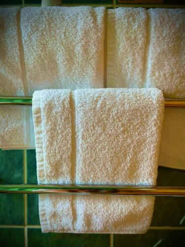 three white towels on a glass shelf in a bathroom at Loch Ness Lodge Hotel in Drumnadrochit
