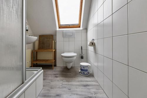 a bathroom with a toilet and a sink and a window at Ferienwohnung AHOI Thiessow in Thiessow