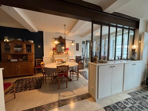 une cuisine et une salle à manger avec une table et des chaises dans l'établissement Dodo et tartines The10-12, à Bayeux