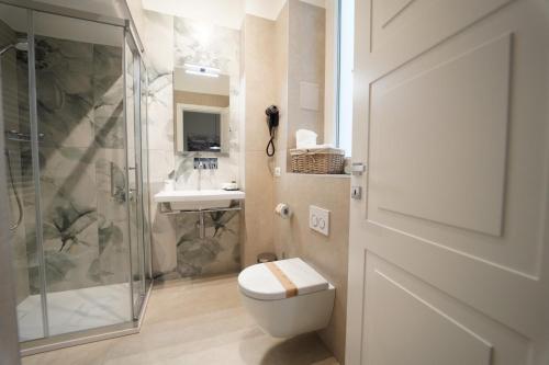 a bathroom with a toilet and a shower and a sink at Annunziatella Suite & Rooms in Matera