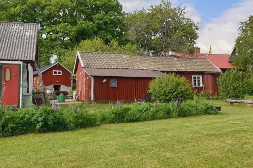a couple of red barns and a yard with a yard at Ekebacken Gård & Mc-camping in Blidsberg
