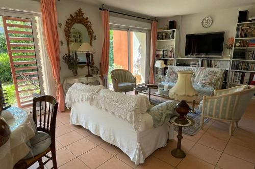 ein Wohnzimmer mit einem weißen Sofa und Stühlen in der Unterkunft The Flower- Townhouse with air conditioning and garden! in Montpellier