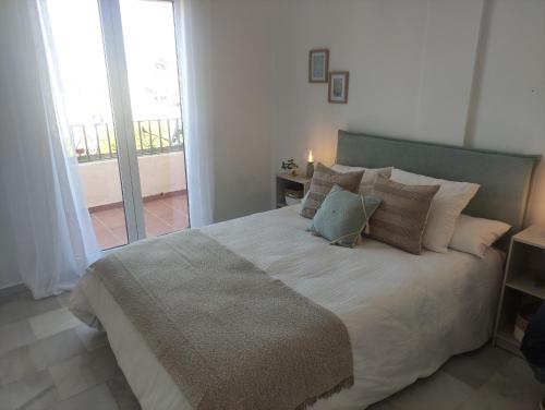 Ένα ή περισσότερα κρεβάτια σε δωμάτιο στο Ático en Nerja con vistas espectaculares