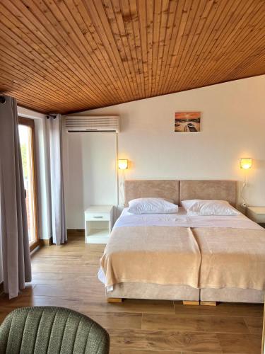 a bedroom with a large bed with a wooden ceiling at Rubin Jelsa in Jelsa
