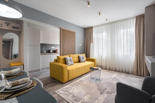 a living room with a yellow couch and a table at Dreamy City Center in Bucharest