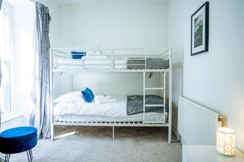a bedroom with a bunk bed and a blue stool at Marazion Beach Town House with Private Parking in Marazion