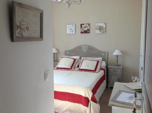 a bedroom with a bed with two red and white pillows at mas la Mouillere in Camélas