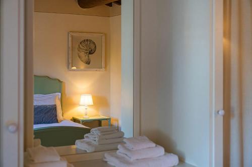 a room with a bed and a mirror and towels at Agriturismo Torreghiotta in Pistoia
