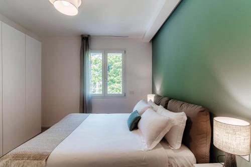 a bedroom with a large bed and a window at Lario Suite Apartments by Quokka 360 - With parking Next to Como City in Como