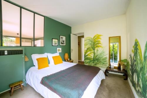 une chambre avec un grand lit avec des oreillers jaunes dans l'établissement Paris Boulogne Parc des Princes Roland Garros Terrasse, à Boulogne-Billancourt