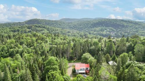 an rv parked in the middle of a forest at Havre de détente avec foyer et spa in Sainte-Lucie-de-Doncaster