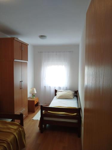 a bedroom with a bed and a window at Apartman Mira Sabunike 1 in Privlaka