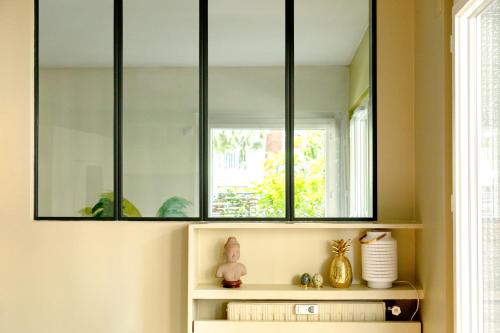 un miroir au-dessus d'une étagère dans une pièce dans l'établissement Paris Boulogne Parc des Princes Roland Garros Terrasse, à Boulogne-Billancourt