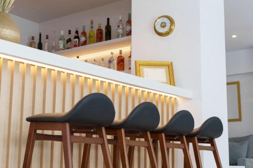 a row of chairs sitting at the bottom of a bar at Gallery Central Piraeus Port in Piraeus