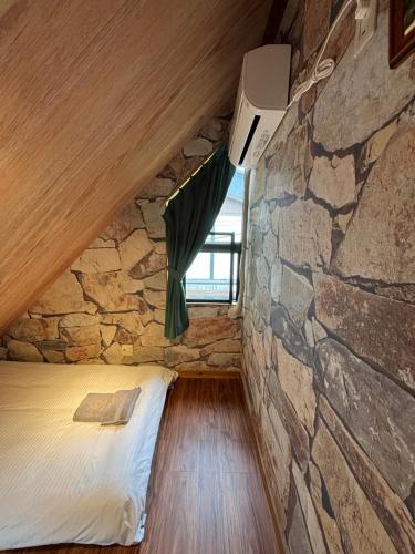 a room with a bed in a stone wall at 箱根シャレー コンビニ近く 海賊船に乗ろう 箱根中心 in Hakone