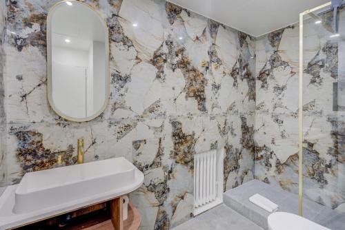 une salle de bain avec un lavabo et un miroir dans l'établissement Luxurious Apartment - Champs Elysées - With AC, à Paris