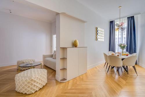 un salon blanc avec une table et des chaises dans l'établissement Luxurious Apartment - Champs Elysées - With AC, à Paris