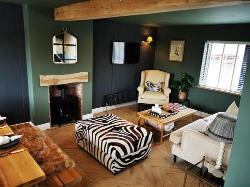 a living room with a zebra printed ottoman in front of a fireplace at The Architects Home in Stow on the Wold