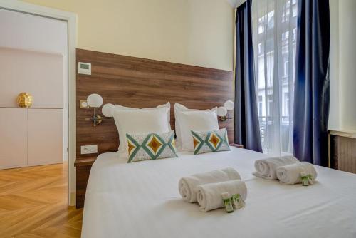 une chambre avec un grand lit blanc avec des serviettes dessus dans l'établissement Luxurious Apartment - Champs Elysées - With AC, à Paris