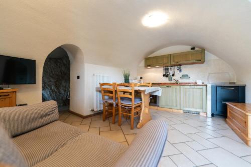a kitchen with a table and chairs in a room at Maso Salim Relax Apartments in Drena