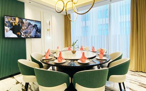 a dining room with a table and green chairs at SIHA Hotel & Casino in Sihanoukville