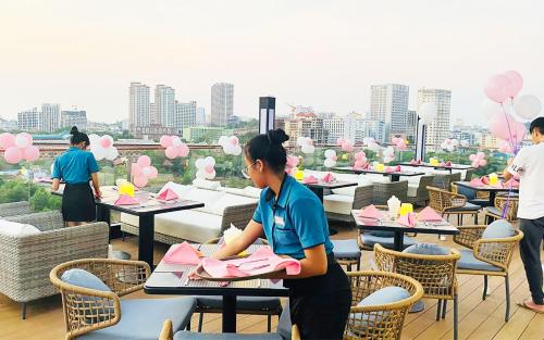 a group of people sitting at tables with pink balloons at SIHA Hotel & Casino in Sihanoukville