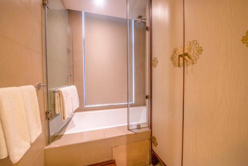 a bathroom with a shower and a sink with a window at Vivanta Colombo, Airport Garden in Negombo