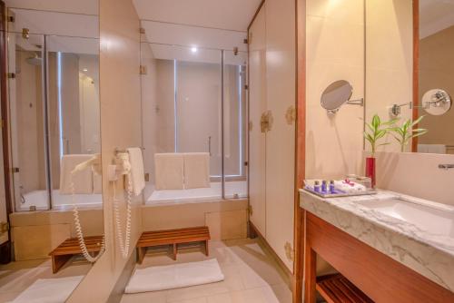 a bathroom with a shower and a sink at Vivanta Colombo, Airport Garden in Negombo
