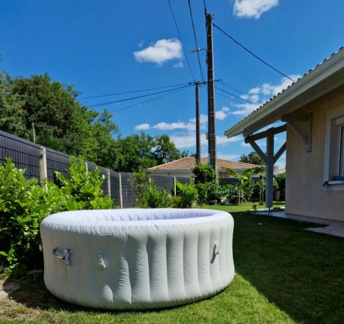 une grande baignoire blanche installée dans la cour d'une maison dans l'établissement Maison Solyne Andernos les Bains, à Andernos-les-Bains