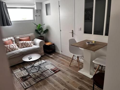 un salon avec un canapé et une table dans l'établissement Logement proche gare et Versailles, à Marly-le-Roi