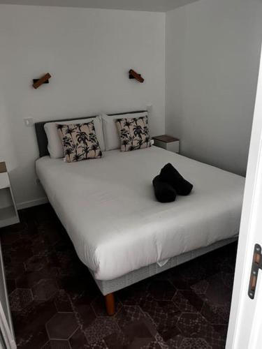- un lit blanc avec un chapeau noir au-dessus dans l'établissement Logement proche gare et Versailles, à Marly-le-Roi