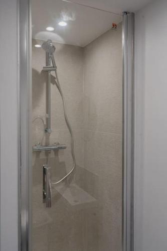 une douche dans une salle de bain avec une porte vitrée dans l'établissement Studio La Dent du Chat, à Chambéry