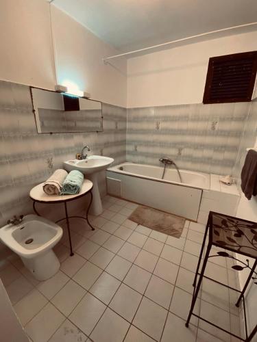 a bathroom with a toilet and a tub and a sink at Chambre d'Hôtes Créole Bas du Fort in Le Gosier