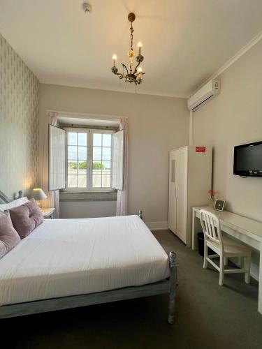 a bedroom with a bed and a desk and a chandelier at Thomar House in Tomar