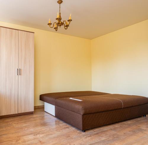 a bedroom with a brown bed and a cabinet at Golden Dune Apartment in Klaipėda