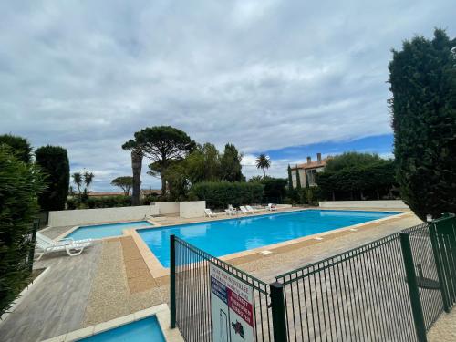 une piscine entourée d'une clôture dans l'établissement St Tropez Plage, à Saint-Tropez