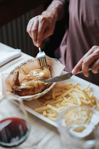 a person eating food with a plate of french fries at Albergo Robiei in San Carlo