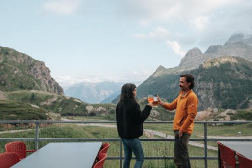 a man and woman drinking wine in the mountains at Albergo Robiei in San Carlo