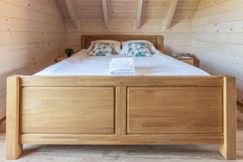 a bedroom with a bed in a wooden cabin at Domki Gorczański Zakątek - Jacuzzi in Nowy Targ