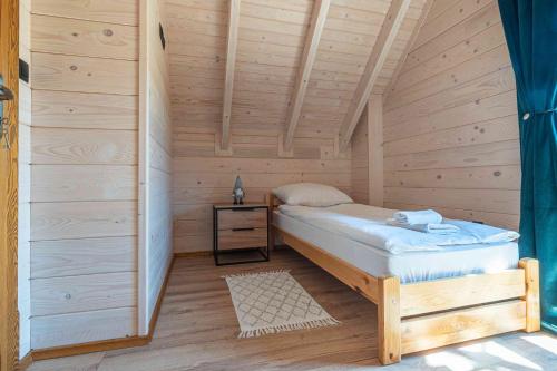 a bedroom with a bed in a wooden cabin at Domki Gorczański Zakątek - Jacuzzi in Nowy Targ