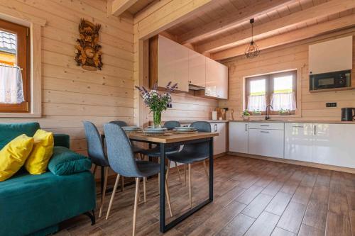 a kitchen and dining room with a table and chairs at Domki Gorczański Zakątek - Jacuzzi in Nowy Targ